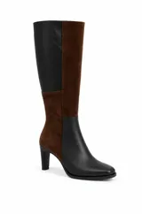 Bota alta bicolor con diseño de paneles en combinación de cuero negro y gamuza marrón. Cuenta con punta cuadrada suave, caña recta alta y taco fino.