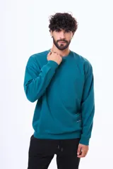 Buzo de felpa verde petróleo con cuello redondo, corte oversize y estampa en la espalda con las palabras Pasado, Presente y Futuro.