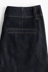 Pantalón de jean estilo wide leg, de tiro alto y corte holgado. Confeccionado en denim rígido de color azul oscuro, presenta costuras a contratono, bolsillos laterales al bies y bolsillos traseros decorativos.