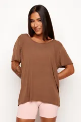 Remera de corte holgado y diseño minimalista, confeccionada en una mezcla de viscosa, lino y elastano. Presenta cuello redondo amplio y mangas cortas con terminación al corte.