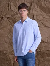 Camisa de manga larga con estampado de rayas verticales finas en color azul y blanco. Presenta cuello clásico, cierre frontal con botones y un bolsillo en el pecho.