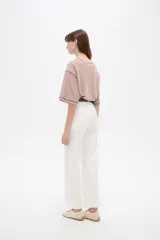 Pantalón de algodón color blanco, de tiro alto y corte flare, con bolsillos y detalles de vivos.