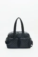 Bolso tipo shopper color marrón con diseño matelassé. Tiene doble asa corta y correa larga desmontable. Incluye llavero de corazón y dijes desmontables, y compartimento interior para notebook.