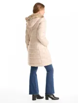 Campera puffer larga con diseño capitoneado, cierre frontal completo, bolsillos laterales con cierre y capucha desmontable con borde de piel sintética.