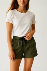 Short color verde militar de poliéster, holgado y de calce medio, con cintura elástica ajustable con cordón negro.