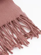 Pashmina de textura suave en color gris, con diseño rectangular y terminaciones con flecos en los extremos.