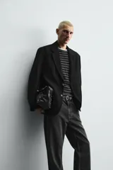Blazer de corte relajado confeccionada en tejido fluido con mezcla de viscosa. Presenta cuello con solapas de muesca, manga larga con puños abotonados, bolsillos de solapa en la cadera y cierre frontal con botones.