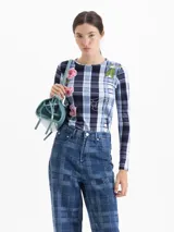 Remera de manga larga con cuello redondo, confeccionada en tela de punto con estampado de cuadros y flores. Presenta un ajuste al cuerpo.