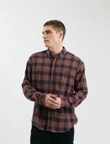 Camisa de franela a cuadros con cuello button-down, manga larga y botones de madera. Presenta dos bolsillos tipo parche en el frente con cierre de botón.