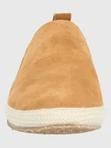 Alpargata Hush Puppies de gamuza color mostaza, con suela de yute trenzado y base de goma. Presenta un detalle elástico lateral con diseño multicolor y forro interior de algodón orgánico.