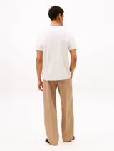 Remera de manga corta confeccionada en tejido de piqué de algodón, con cuello redondo y bolsillo de parche en el pecho. Presenta detalles tricolores en el cuello y un diseño de corte regular.