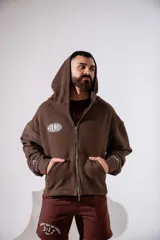 Campera con capucha y cierre frontal, de corte boxy y diseño holgado en color marrón chocolate. Presenta logo estampado en el pecho y detalles en las mangas.