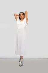 Vestido largo de algodón tusor en color blanco, con volados en las sisas que simulan mangas y aberturas laterales en la falda.