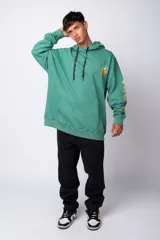 Buzo canguro gris claro de corte oversize, con capucha y cordones negros con letras blancas. Presenta un bolsillo tipo canguro y un estampado pequeño en el pecho y otro en la manga.