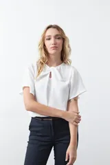 Top negro de manga corta con detalle de nudo en el escote y abertura tipo gota. Presenta una silueta relajada y textura sutil en la tela.