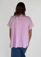 Camisa negra de manga corta con cuello redondo y detalle de volados frontales. Presenta cierre central con botones de madera y terminaciones con puntilla en el escote.