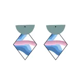 Par de aros colgantes con forma geométrica. La parte superior es un semicírculo plateado con glitter, y la parte inferior es un rombo blanco con franjas horizontales en tonos azul, marrón y gris.