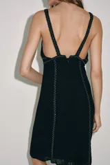 Vestido midi de Zara Woman Collection color negro, con escote en pico, tirantes finos y detalles de bordados con aplicación de abalorios. Cuenta con forro interior a tono y cierre con cremallera oculta en costura.