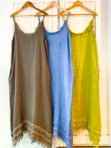 Vestido midi de lino con breteles finos, escote redondo y detalle de flecos en el ruedo y el escote.