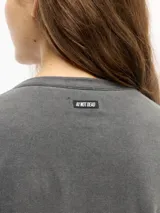 Remera de manga corta gris con efecto gastado fade, calce ajustado y cuello redondo.