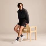 Championes Lacoste modelo L001, de diseño urbano con base blanca, detalles en gamuza beige y refuerzo azul en el talón. Presenta el logo del cocodrilo bordado en el lateral y suela de goma blanca.