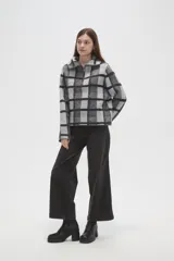 Sweater de tejido jacquard con diseño de cuadros, cuello solapa y cierre frontal parcial. Presenta un corte holgado y mangas largas.