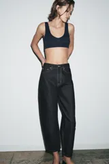 Jeans de tiro medio con corte tapered, confeccionados en denim de color negro con costuras en contraste. Presentan diseño de cinco bolsillos, trabillas en la cintura y cierre frontal con cremallera y botón.