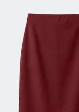 Pollera midi de corte recto y tiro alto, confeccionada en tela lisa con una abertura lateral en el ruedo.
