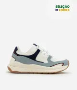 Championes estilo jogging con diseño de recortes contrastantes en tonos blanco, azul y gris. Presenta una parte superior de mesh respirable con sobreposiciones de poliuretano, forro suave y suela robusta de color crema con base marrón.