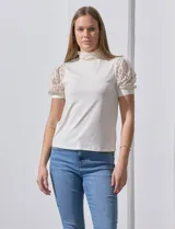 Blusa color blanco de crepe, marca Cable & Gauge. Cuello halter con detalles plisados y mangas cortas de encaje con destellos brillantes.