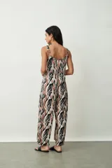 Monoprenda (jumpsuit) de mujer con estampado abstracto en tonos negro, marrón y blanco. Presenta escote en V, tirantes finos ajustables y pierna ancha tipo palazzo.