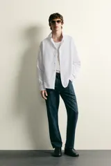 Camisa de corte regular fit confeccionada en tejido de algodón. Presenta cuello italiano, manga larga con puños abotonados y cierre frontal mediante botonadura.