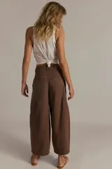 Pantalón chino de algodón marrón, de tiro alto y pierna ancha estilo wide-leg, con largo al tobillo, bolsillos laterales y cierre frontal.