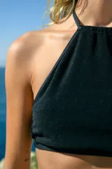 Top negro de tela de toalla con tiras de tricot a tono, regulable en cuello y espalda.