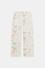 Jeans de tiro bajo y corte suelto con diseño de cinco bolsillos, trabillas para cinto y cierre frontal con cremallera y botón metálico, adornado con un estampado floral en tonos rosados y verdes sobre base clara.