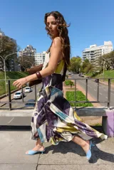Vestido largo sin mangas de corte evasé con estampado abstracto en tonos bordó, beige y rosado, escote en V y tirantes finos.