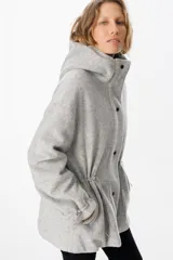 Campera de paño con capucha, cierre frontal con botones a presión y cordones ajustables en la cintura. Presenta un diseño de corte recto con mangas largas y puños ajustables.