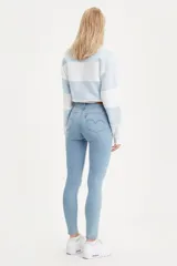 Jeans de tiro alto color celeste, ajustados en cadera y muslos, con pierna skinny y cierre de cremallera.