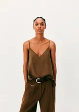 Blusa verde militar de tirantes finos, con escote en V y costuras frontales decorativas.