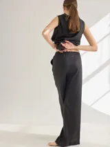 Pantalon de corte recto y tiro medio, confeccionado en lino, con cintura elastizada y tajos laterales en el ruedo.