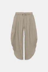 Pantalón ZARA Woman Collection de lino 100%, de tiro medio y color gris claro, con cintura elástica ajustable mediante cordones y bajo redondeado con aberturas laterales.