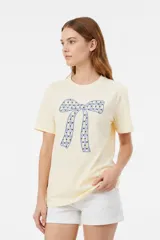 Remera blanca de manga corta y cuello redondo, confeccionada en algodón, con un diseño holgado y estampado frontal de estrella roja con textura y detalles de estrellas pequeñas.