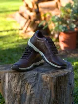 Championes de cuero marrón con cordones al tono y suela de goma bicolor en tonos beige y marrón oscuro.