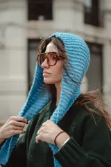 Capucha tejida en lana de color azul vibrante, con textura de punto grueso y diseño envolvente.