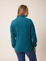 Buzo de polar con cuello alto y medio cierre frontal. Presenta un diseño de manga larga con puños elásticos y logo bordado en el pecho.