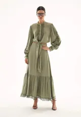 Falda larga de corte fluido en color verde oliva, con diseño de volado en el ruedo y detalle de encaje delicado en el borde inferior.