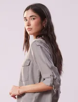 Camisa celeste de tencel con cuello con solapa, abertura central con botones ocultos, bolsillos delanteros y mangas largas regulables con presilla y botón.