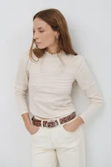 Polera de manga larga con cuello alto y detalle de volados en el borde. Confeccionada en tejido acanalado de textura suave y ajuste al cuerpo.