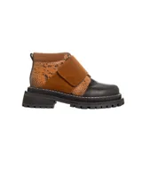 Botinetas de caña baja con suela track gruesa, combinando cuero negro en la puntera, gamuza marrón en el lateral y detalles de textura animal print tipo serpiente en tonos marrones. Presenta un cierre de solapa con velcro en el empeine.