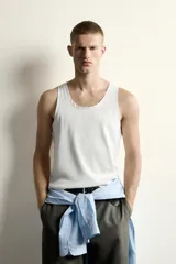 Camiseta sin mangas tipo tank top de corte slim fit, confeccionada en tejido de algodón con elasticidad, cuello redondo amplio y vivos en tejido combinado a tono.